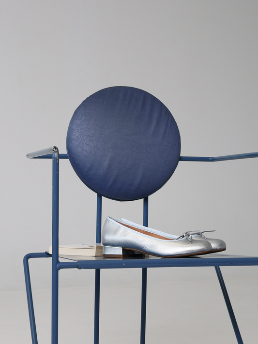 A pair of silver shoes on a blue chair