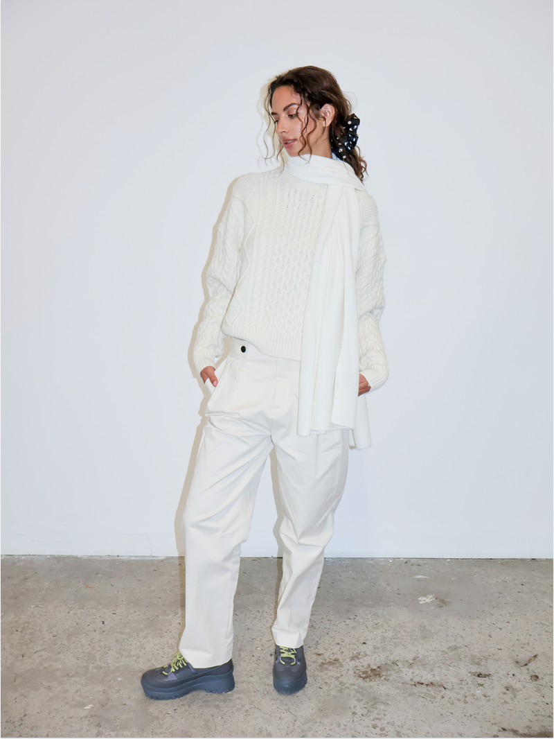 Person wearing a white outfit with a plain background