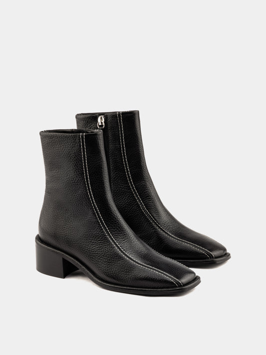 Black ankle boot with white stitching and square heel