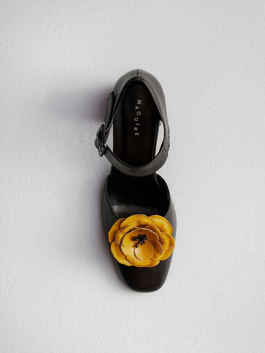 Black heel shoes with a yellow ornament flower