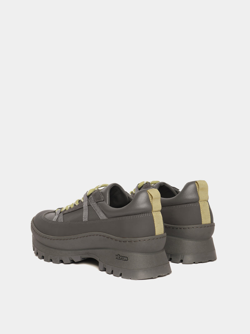 Sneaker with a Vibram anti-slip outsole in grey with lime green laces.