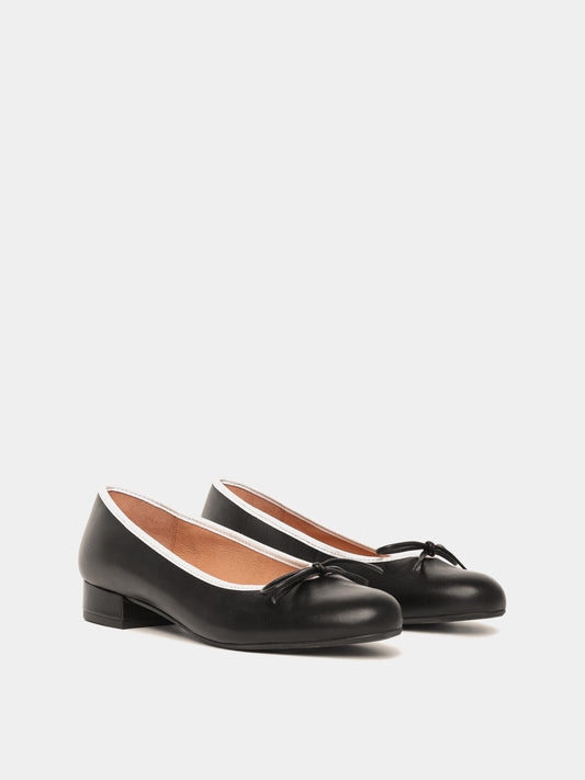 Black ballerina pumps with white piping and black bows