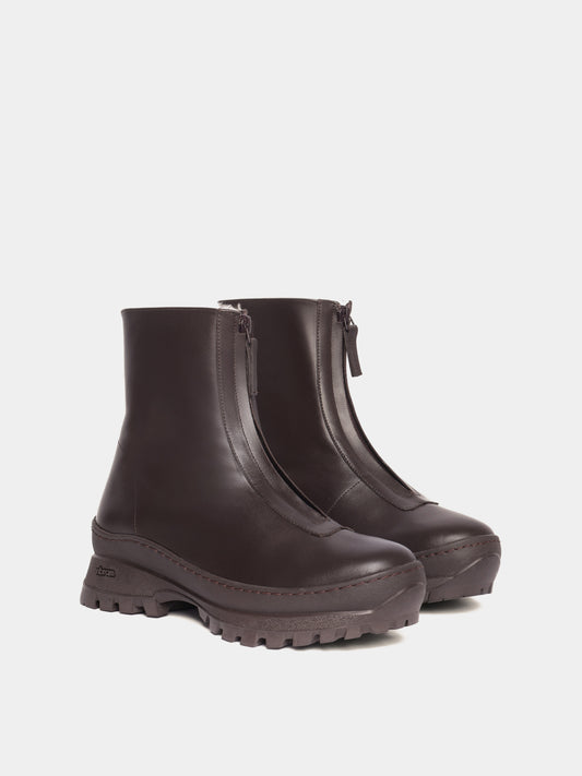 Brown fur-lined boots with a zipper going down the middle and brown vibram soles