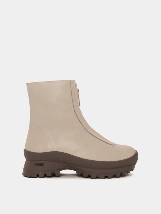 Cream fur-lined boot with a zipper going down the middle and a taupe vibram sole