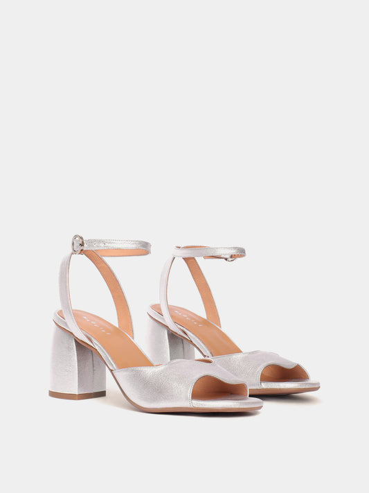 Silver metallic heels with an asymmetric wave design and adjustable ankle straps.