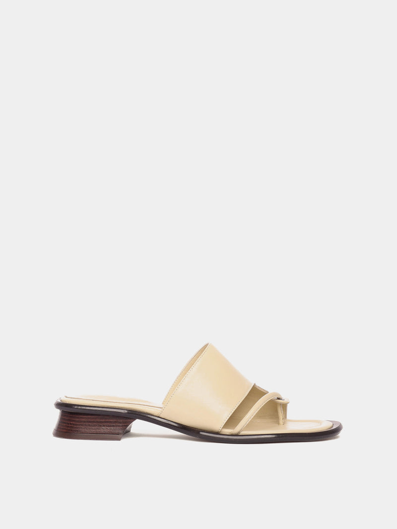 A single beige sandal with a sculptural heel and a soft upper.