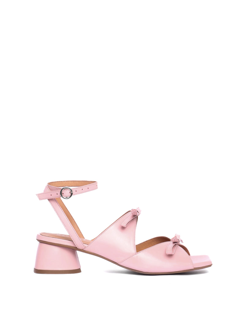 Blush leather heel with two straps adorned with bows and an ankle strap
