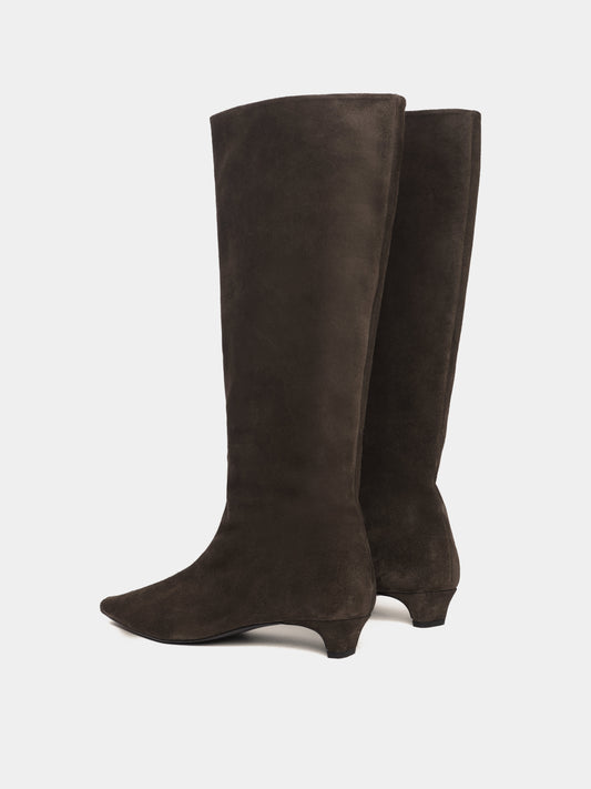 Knee-high brown suede boots with a low heel and pointed toes