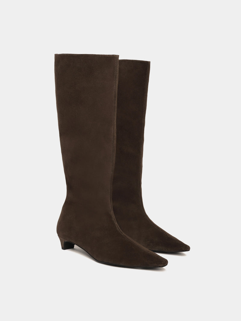 Knee-high brown suede boots with a low heel and pointed toes