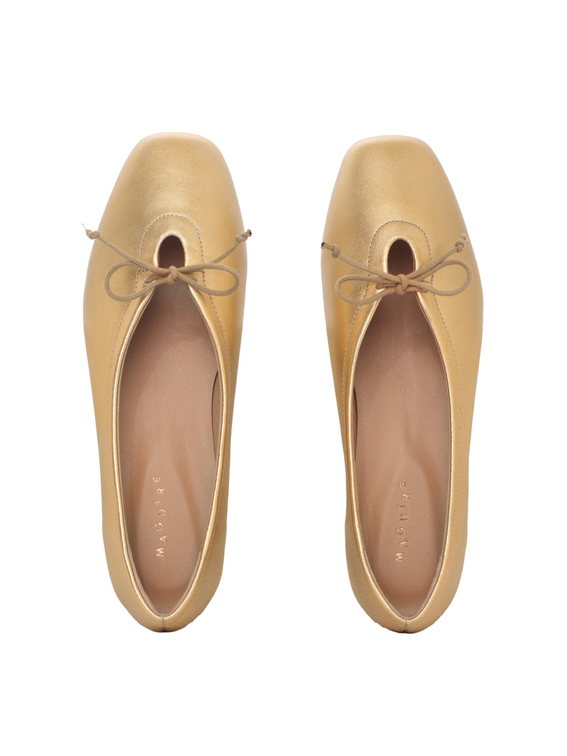 Gold leather ballerina flats with a gold bow