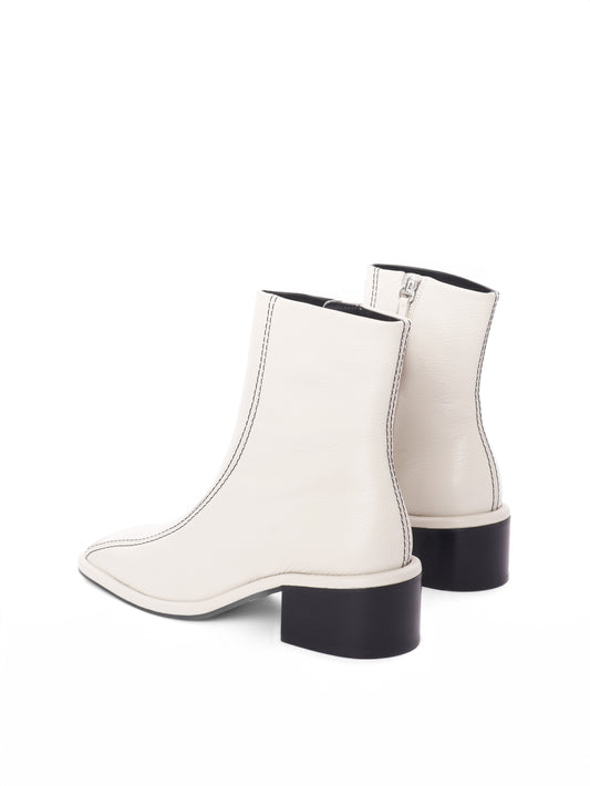 Cream leather ankle boots with black contrast stitching and a block heel