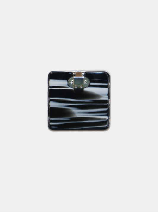 Ecom image of square shoe clip, black with white paint-like strokes, back clasp view.