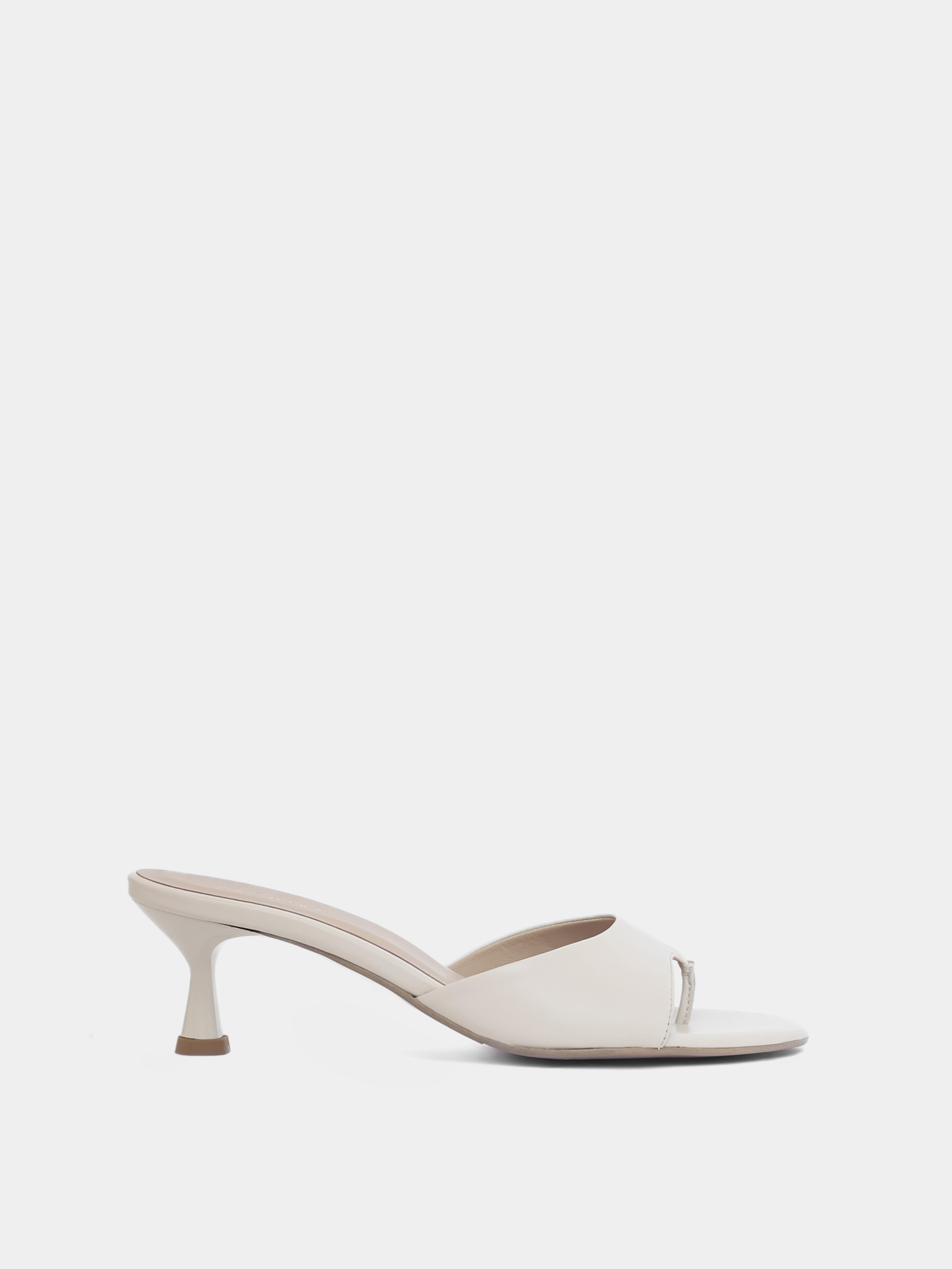 Side view of cream colored open toe heeled sandal on white background