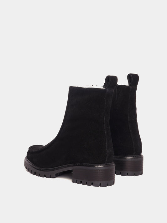 Shearling lined winter boot with a front piping detail, in a black suede with a black lug outsole. 