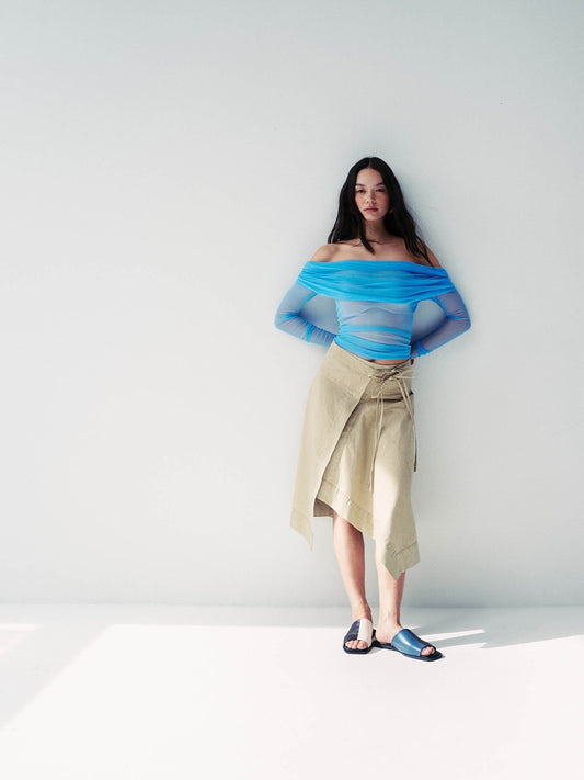 Model wearing a multicolour sandal with a beige skirt and blue transparent top