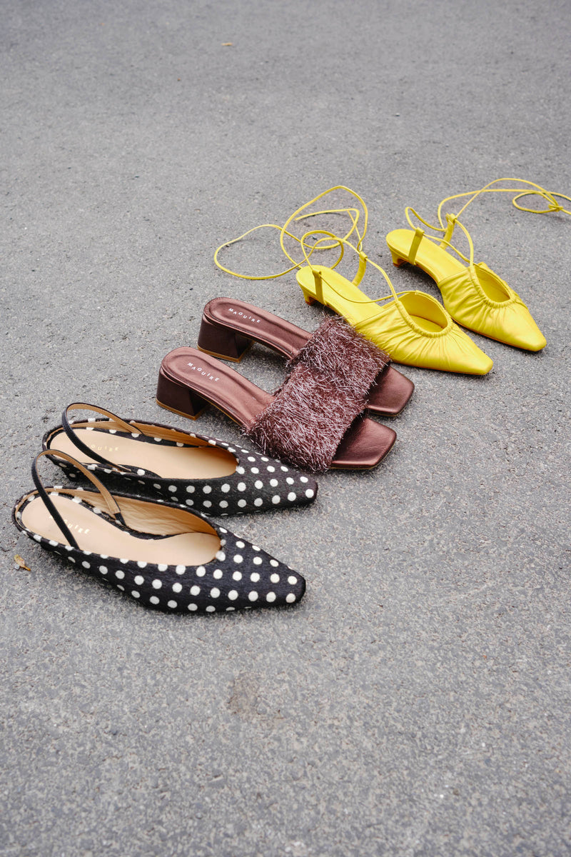 Four pairs of shoes in different colors on a gray surface