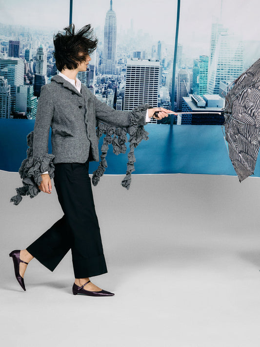 Person holding an umbrella with a cityscape background