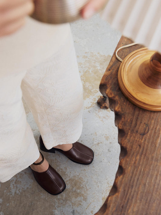 Women's brown heel worn with nude lace pants
