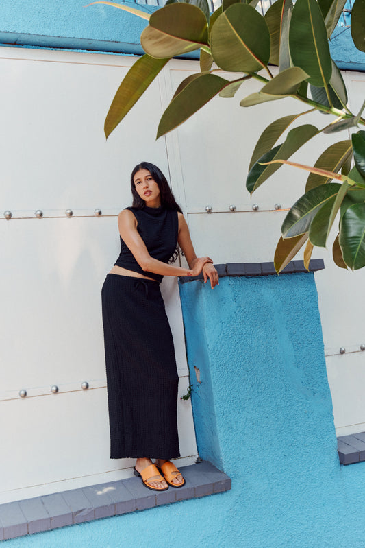Woman wearing orange sandals and black dress