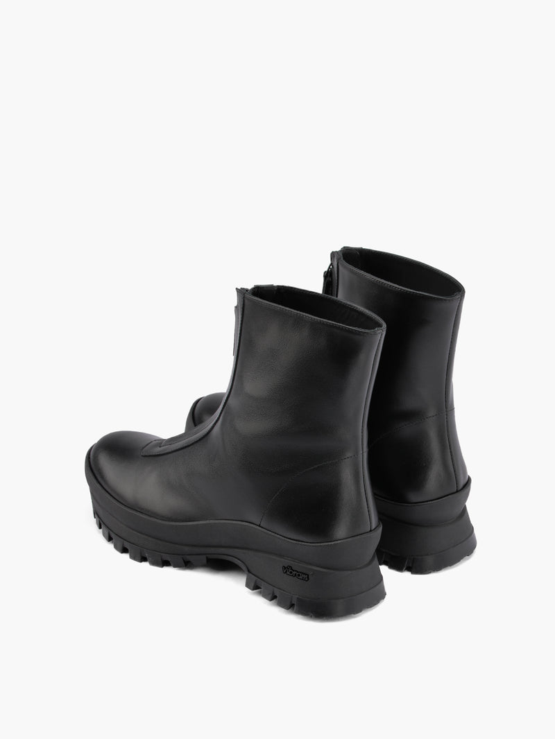 Black fur-lined boots with a zipper going down the middle and black vibram soles