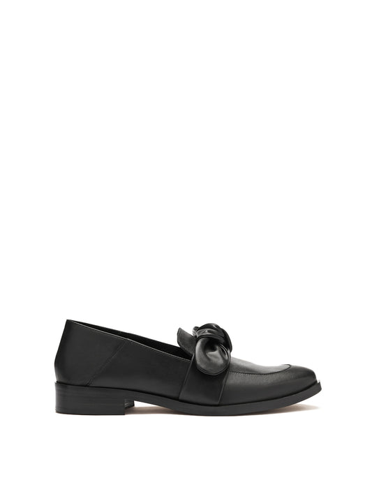 Loafer with a puffy suede bow detail on the vamp, in a black leather. 