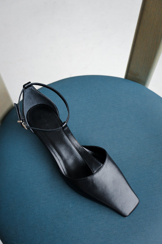 Black high-heeled shoe on a blue chair